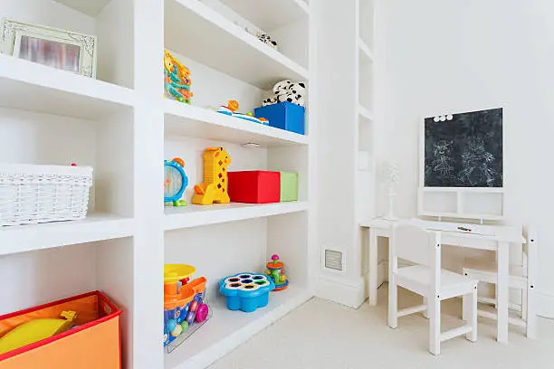 Zoom of white wooden furnitures in child room