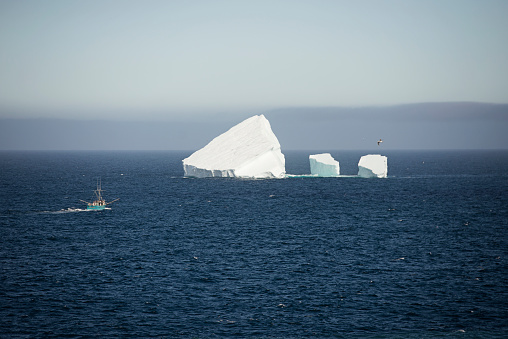 Small iceberg in Newfoundland next to a fishing boat