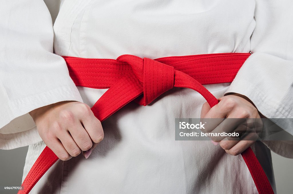 Preparing for battle Cropped image of young women tying a knot and prepering for her battle. Belt Stock Photo