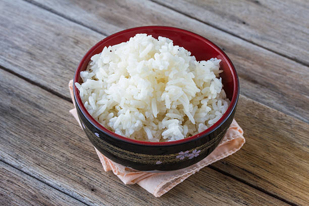 istock rice in cup on wooden background 496483178