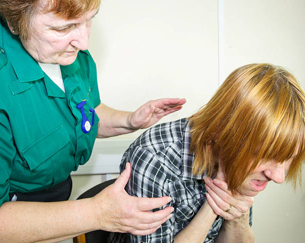 Patient choking being attended to by a paramedic nurse stock photo