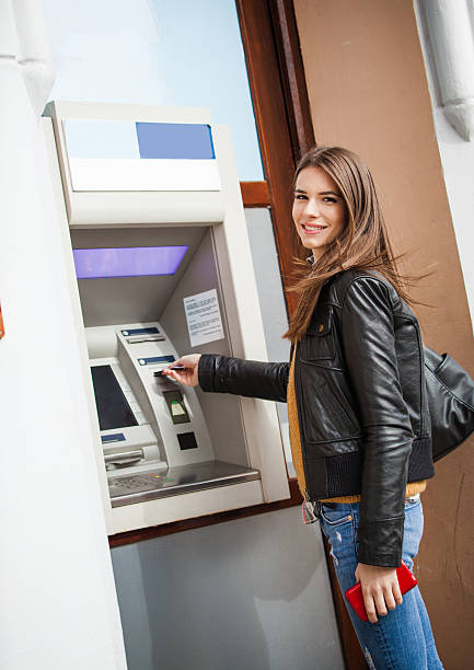 istock Young woman at the ATM machine 496485990