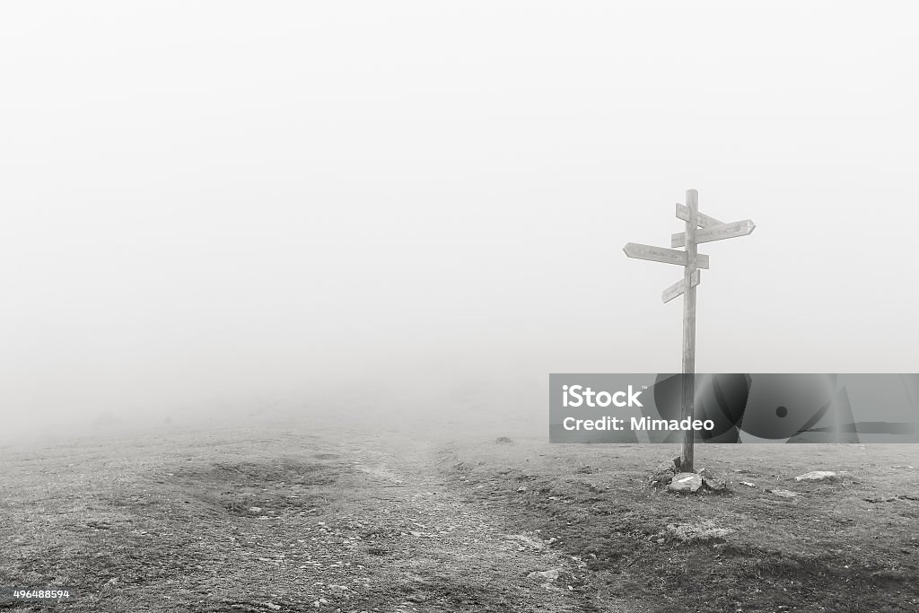 wooden signpost in the fog wooden signpost in the fog. Black and white Fog Stock Photo