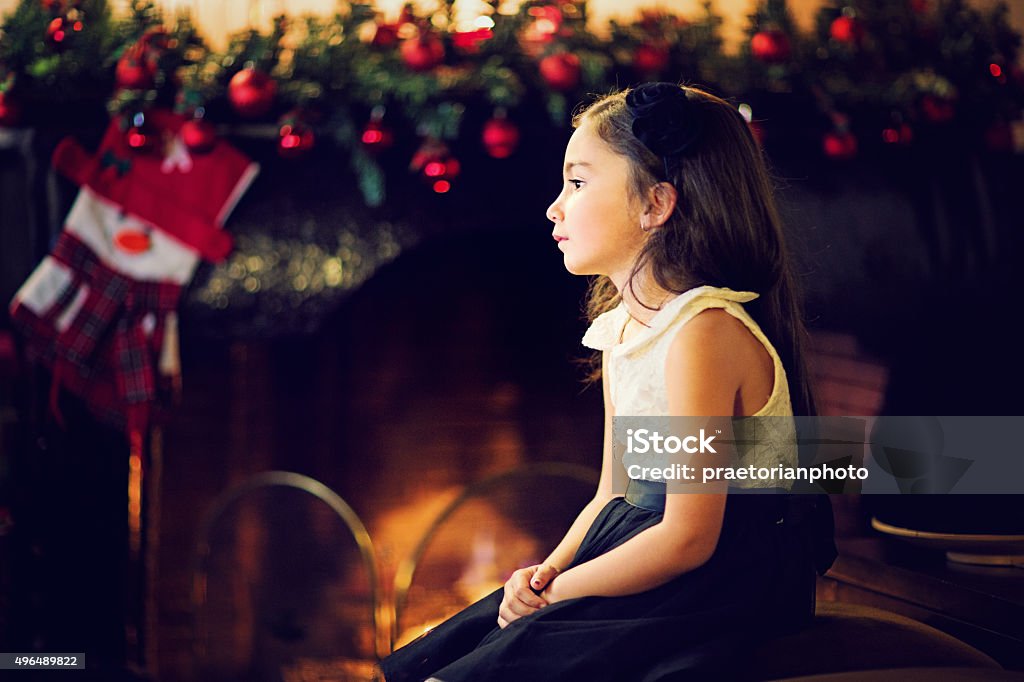 Girl at Xmas Little girl is waiting for Santa at the front of the fireplace. Christmas Stock Photo