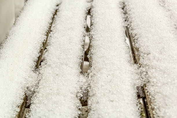 istock Melting snow on a wooden bench, macro 496490100