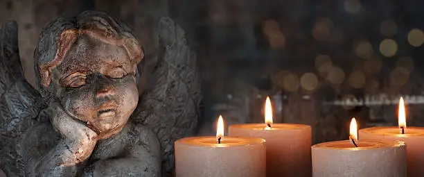 Candles and angel on dark background
