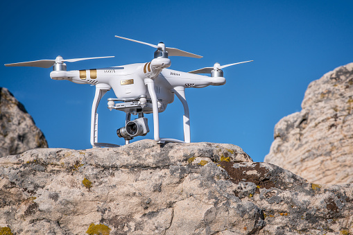 Carr, CO, USA - September 20, 2015: Radio controlled Phantom 3 quadcopter drone on a sandstone cliff ready to take off for aerial photography mission.