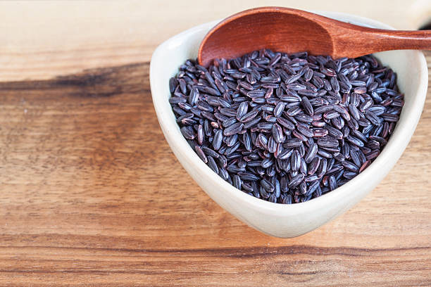istock Black wholemeal rice in bowl, wooden spoon 496493478