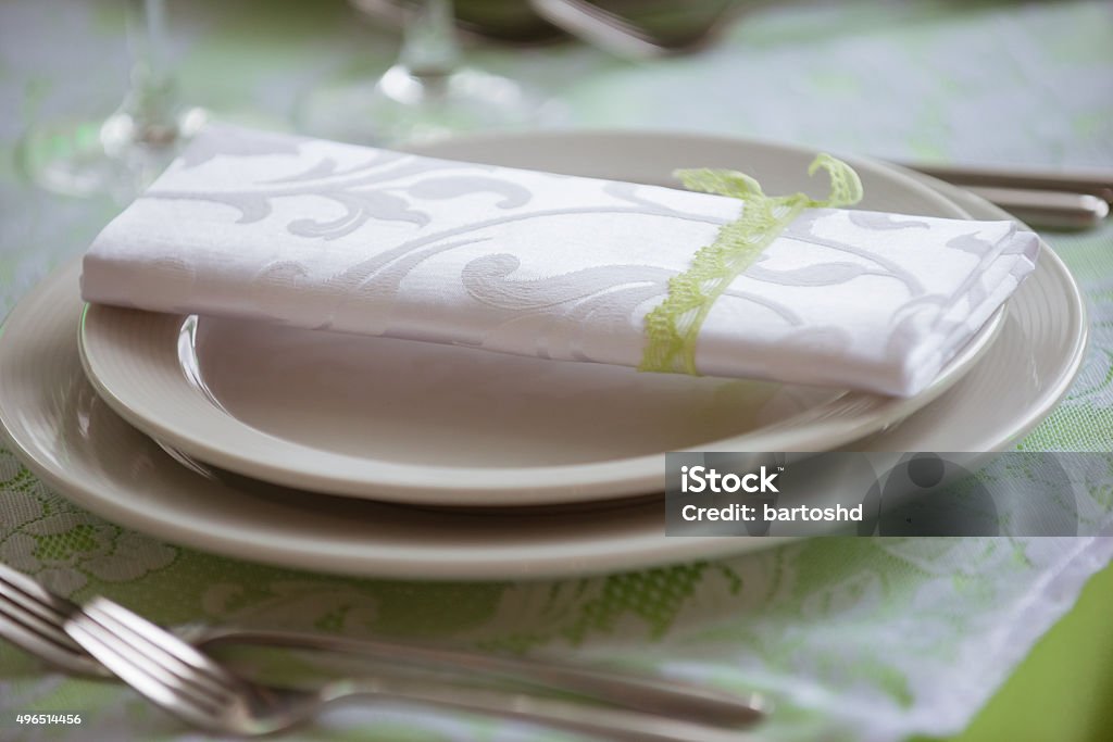 plates and forks on the table served table in a restaurant, focus on a napkin on the plate 2015 Stock Photo