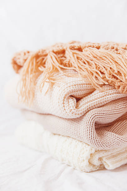 istock Pile of beige woolen clothes on a white background. 496515228