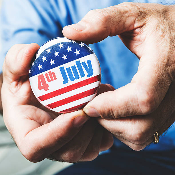 istock man holding a 4th of july campaign button 496516207