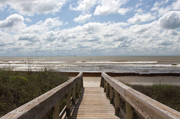 The boardwalk leading to the beach. The clouds against the blue sky