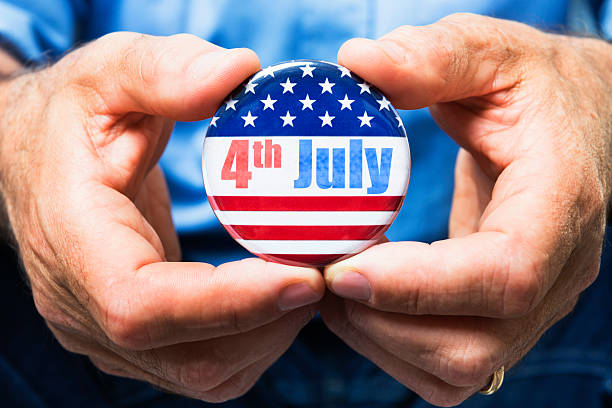 istock man holding a 4th of july campaign button 496516771