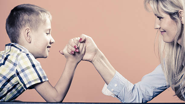 istock Mother and son arm wrestling. 496519556