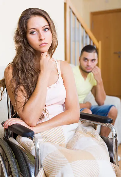 Photo of Sad man with girlfriend in invalid chair