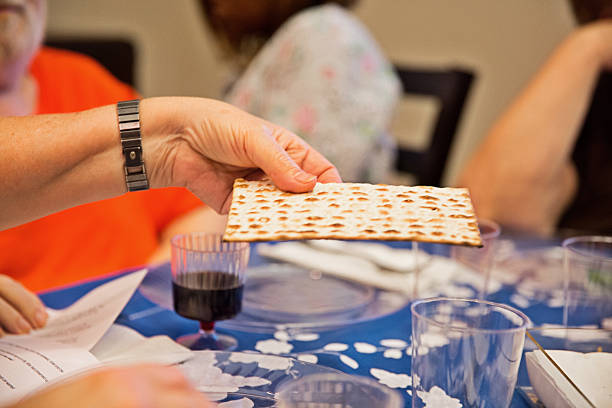 participant à une chambre traditionnelle de pâque juive seder - matzo passover seder judaism photos et images de collection