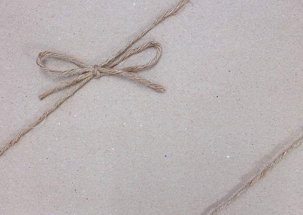 istock String tied in a bow on brown recycled paper 496521029