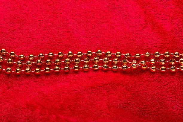 istock Christmas golden beads on red background 496521596