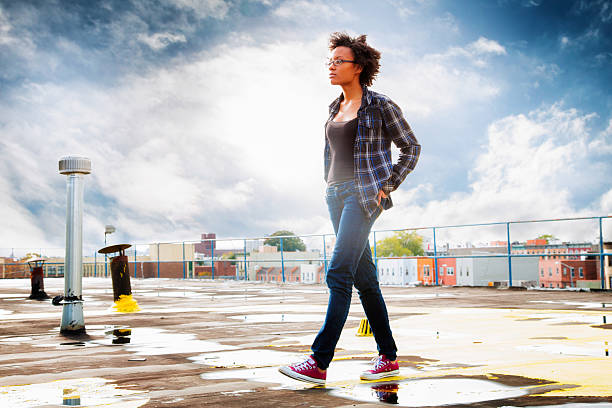 istock Pensive young black woman walking on wet rooftop profile 496522702