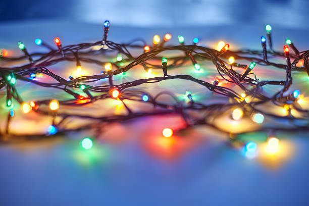 luces de navidad sobre fondo azul oscuro - led diode light bulb bright fotografías e imágenes de stock