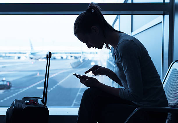 istock Woman using mobile phone in the airport 496523506
