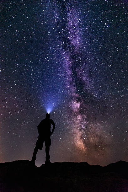 istock Young man gazing into the starry Milky Way Galaxy-stock image 496523764