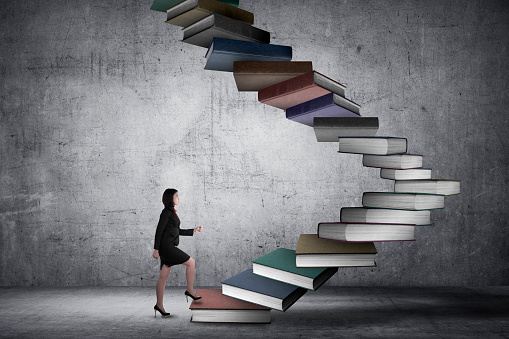 Business person step up flying book that look like stair. Career and education concept