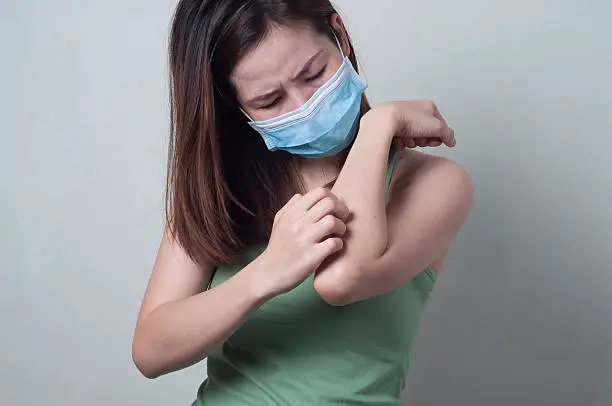 Photo of Asian Beauty woman wearing a  mask are scratching her arms.