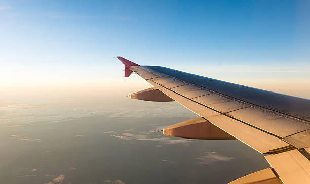 istock Airplane Wing in Flight from window with sunset sky 496549262