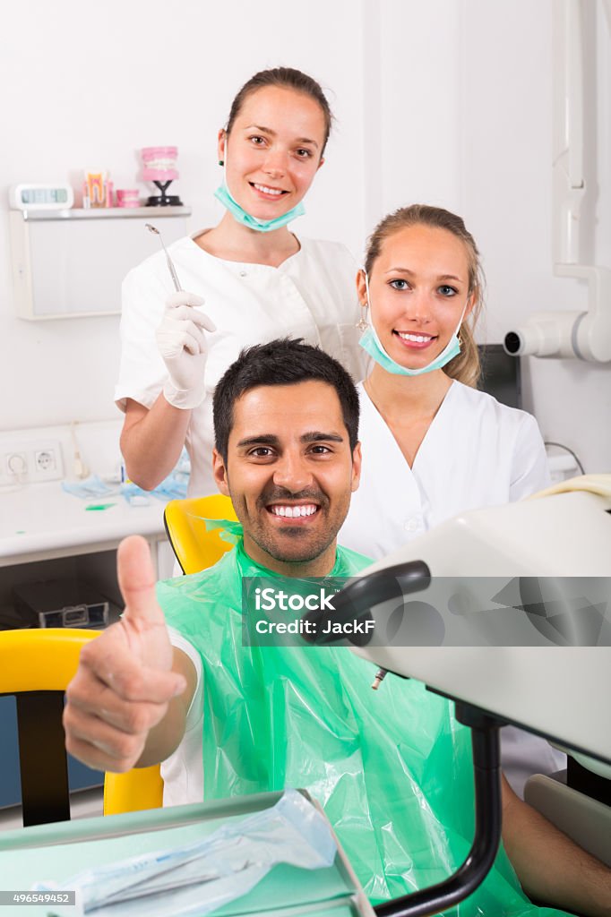 Contented patient at dentist office Contented patient giving thumbs up at dentist office 20-29 Years Stock Photo