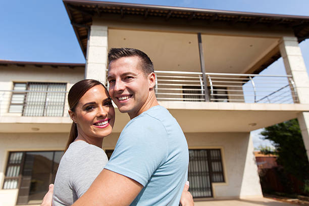 istock couple looking back in front of their house 496550702