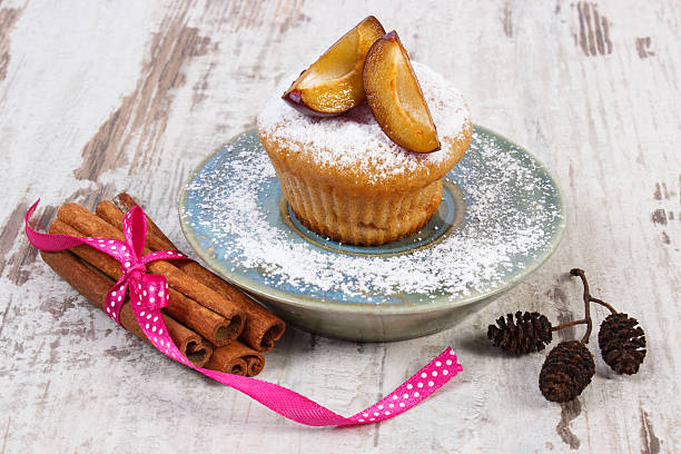 istock Muffins with plums and powdered sugar, cinnamon sticks, delicious dessert 496552364
