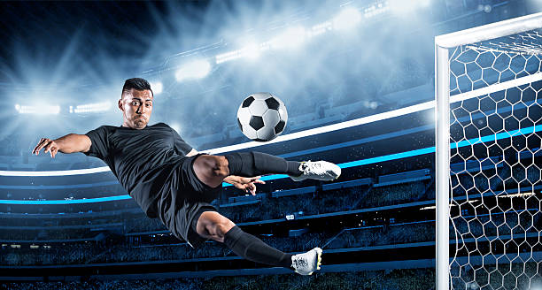 Hispanic Soccer Player kicking the ball Hispanic soccer player in action at night in a large stadium football socks stock pictures, royalty-free photos & images