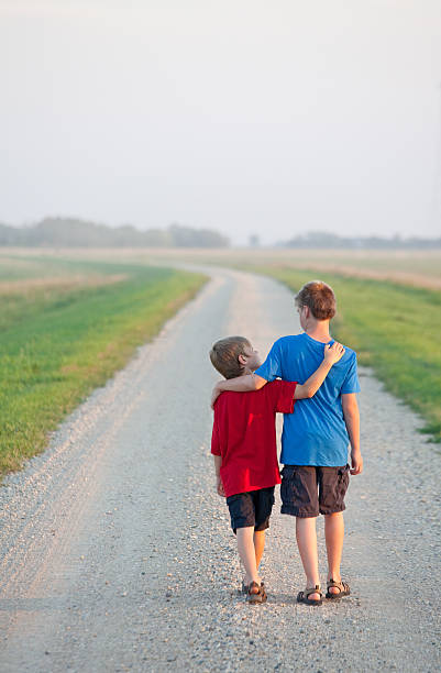 istock Two Boys Walking Down a Country Road 496559853