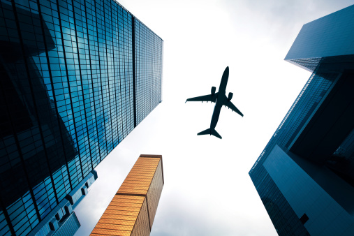 airplane flying above glass office modern office buildings in Hong Kong. china, asia