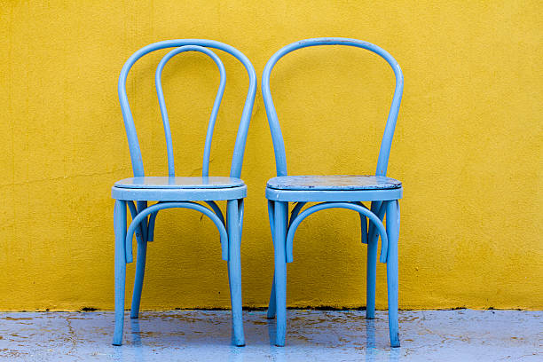 istock Two Vintage Chairs Side by Side Against Yellow Wall, Italy 496563631