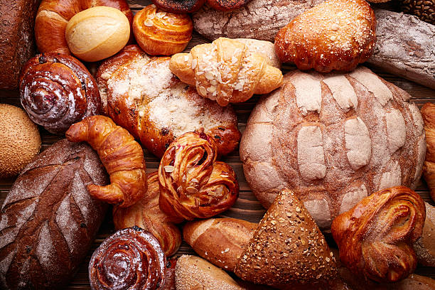 Bread and buns Fresh tasty bread and buns over wooden background bread bakery baguette french culture stock pictures, royalty-free photos & images