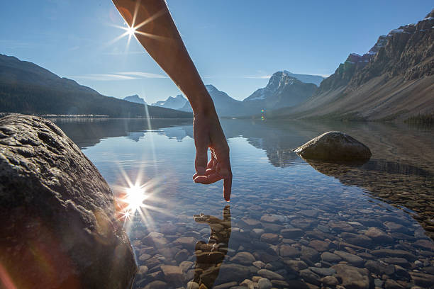 doigt touche la surface d'un lac de montagne, spectaculaire - spring ride photos et images de collection