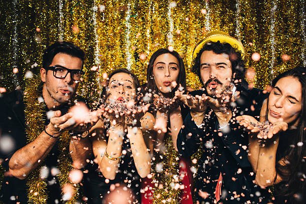 New year party Friends blowing confetti on New Year's Eve - 2016. new year photos stock pictures, royalty-free photos & images