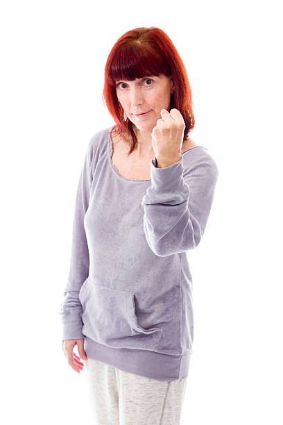 femme mature montrant main isolé sur fond blanc - punching one person shaking fist fist photos et images de collection