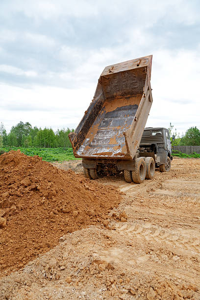 istock dump-body truck unloads a ground on the land 496583920