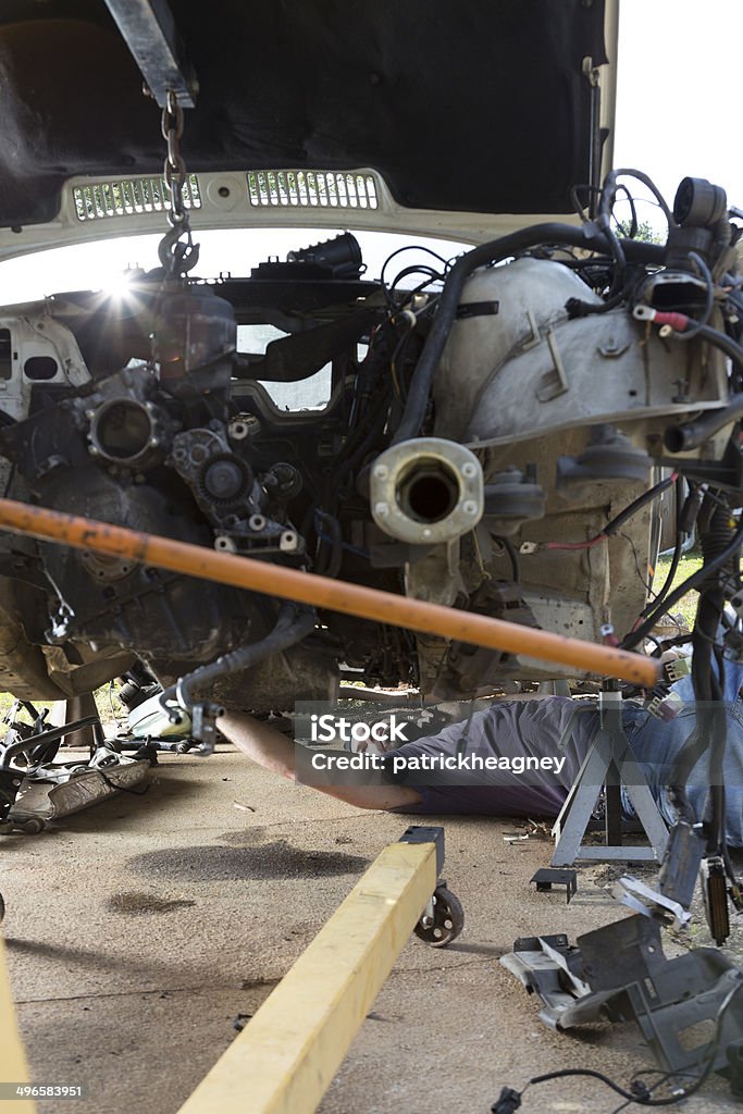 Man Working on a Car A man lays underneath a car to work on it. 30-39 Years Stock Photo
