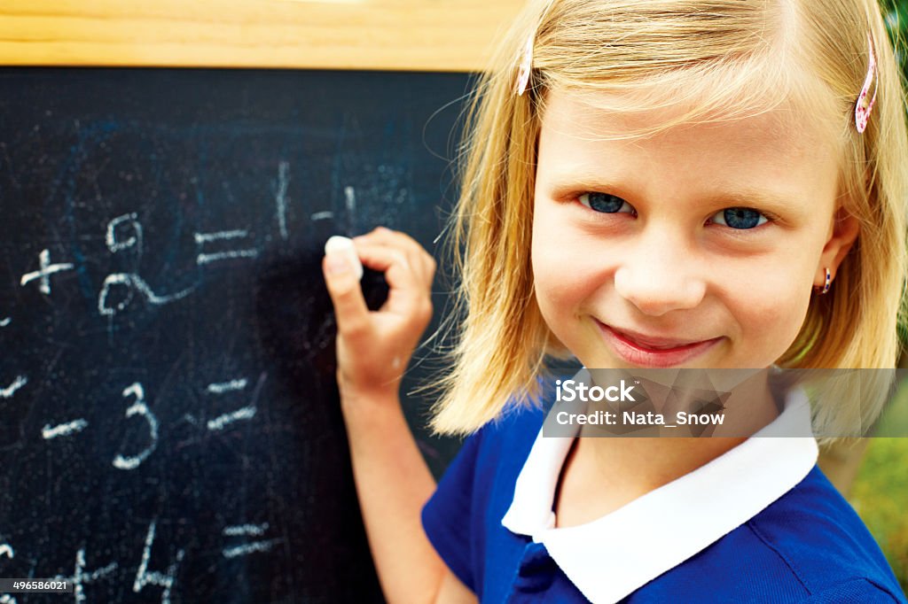 schoolgirl decides on a blackboard mathematical tasks beautiful schoolgirl decides on a blackboard mathematical tasks Chalkboard - Visual Aid Stock Photo