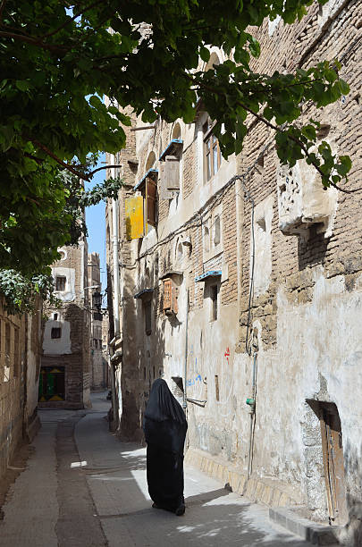 iêmen cena: mulher caminhando na antiga rua em sana'a. - destrination - fotografias e filmes do acervo