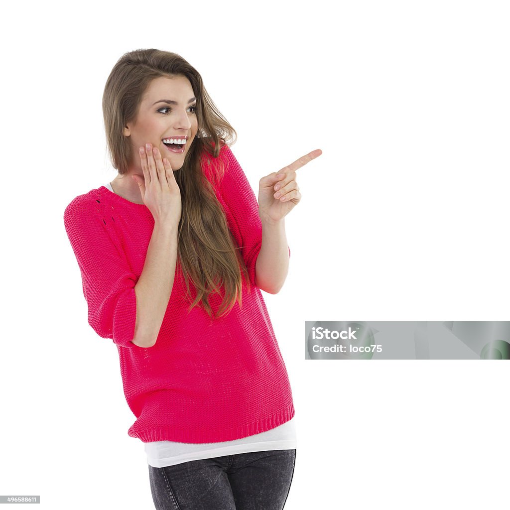 Smiling girl pointing Smiling young woman pointing at empty space. Waist up studio shot isolated on white. 20-24 Years Stock Photo
