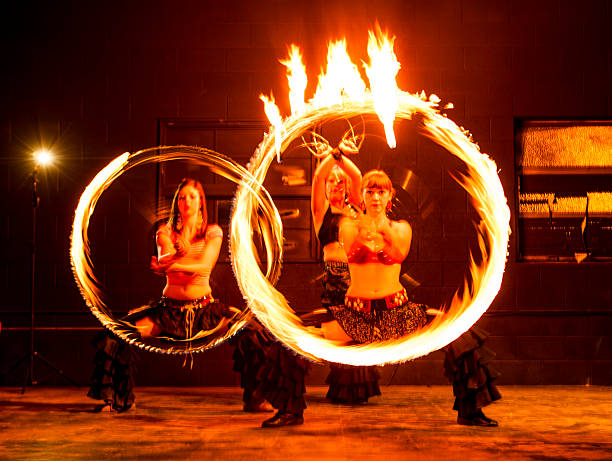 fire dancers spinning cercles avec motion blur - fire dancer photos et images de collection
