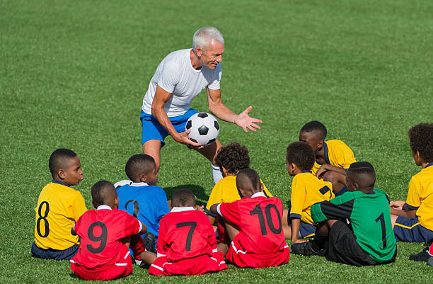 istock Young Football Team With Their Coach 496597389