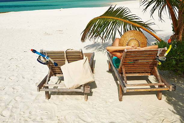 istock Woman at beach with chaise-lounges 496597657
