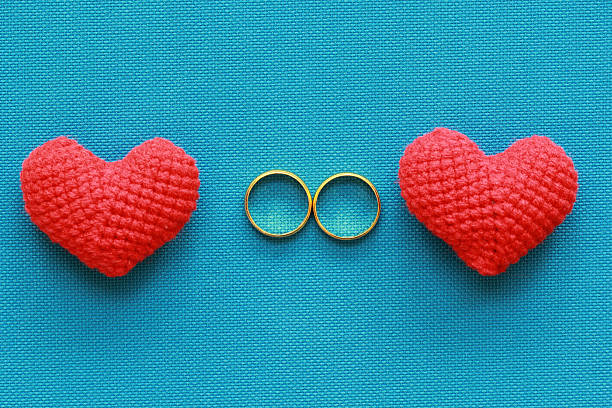 Two wedding rings and red heart shape, valentines day concept Two wedding rings and red heart shape, valentines day concept knitting textile wool infinity stock pictures, royalty-free photos & images