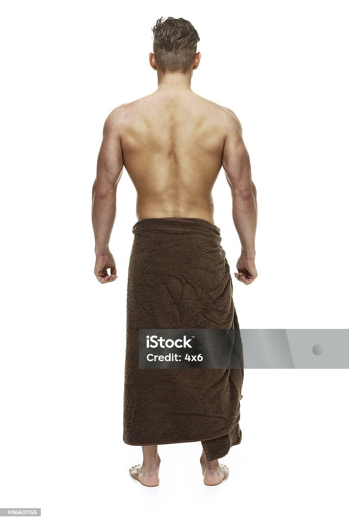 Rear view of muscular man standing & wearing towel Rear view of muscular man standing & wearing towelhttp://www.twodozendesign.info/i/1.png 20-24 Years Stock Photo